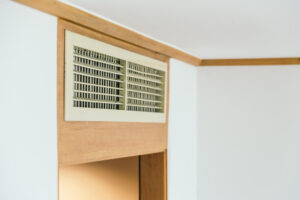 Close-up of a home air vent above a doorway, illustrating furnace airflow and proper warm air circulation in a residential heating system