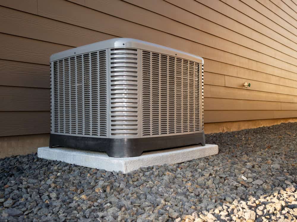 Outdoor AC unit installed on a concrete pad beside a home, illustrating where key components like the AC drain pan and condensate system are located.