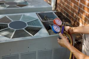 Technician measuring pressure on an outdoor air conditioner