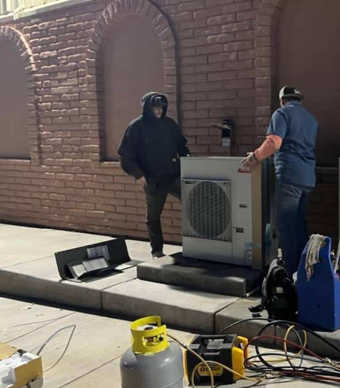 HVAC technicians installing new ac unit